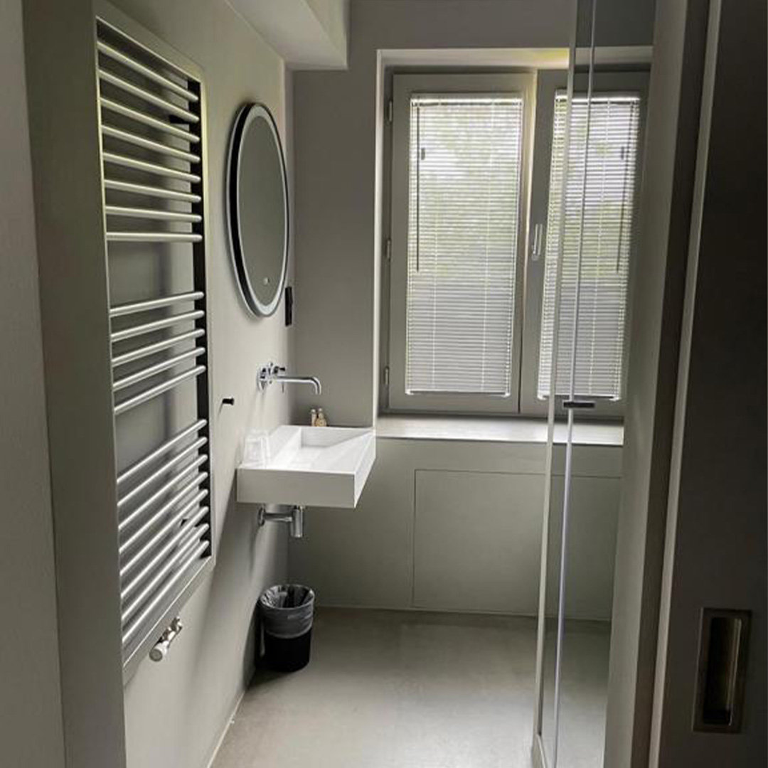 Moderne Badezimmer‑Einrichtung: Waschbecken mit Spiegel und Handtuchheizkörper